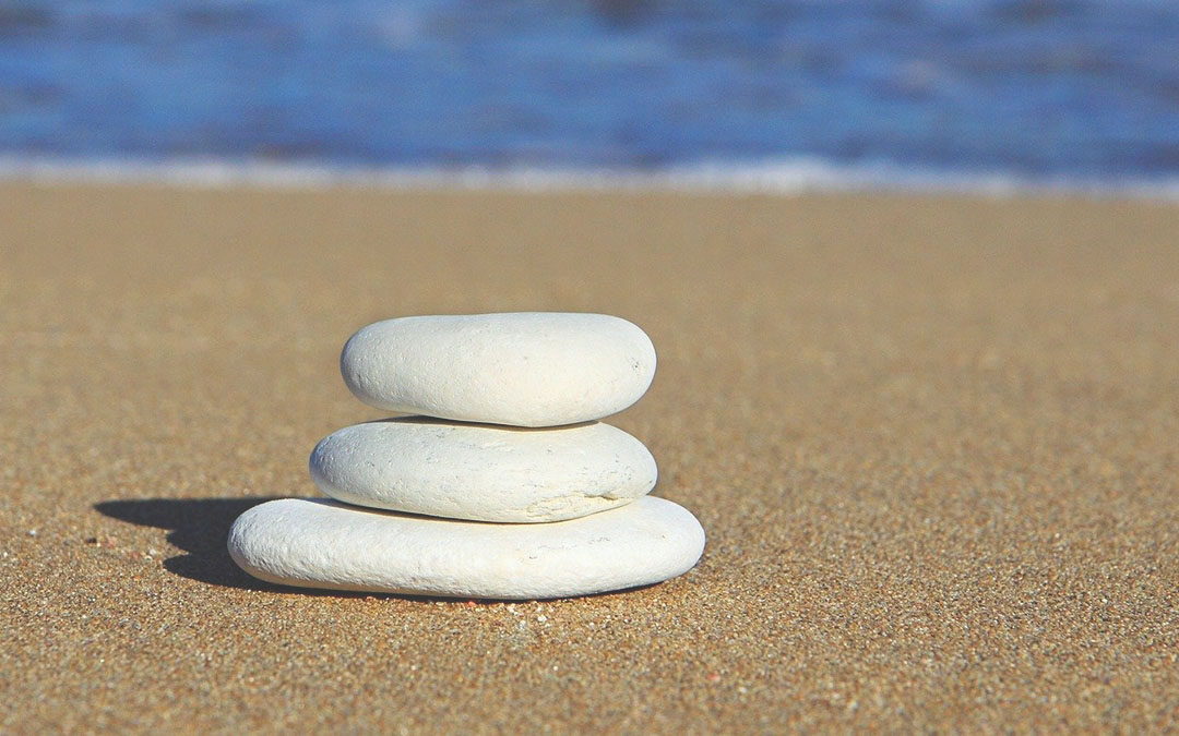 rock stack on a beach for a blog about the mental health benefits of salt therapy